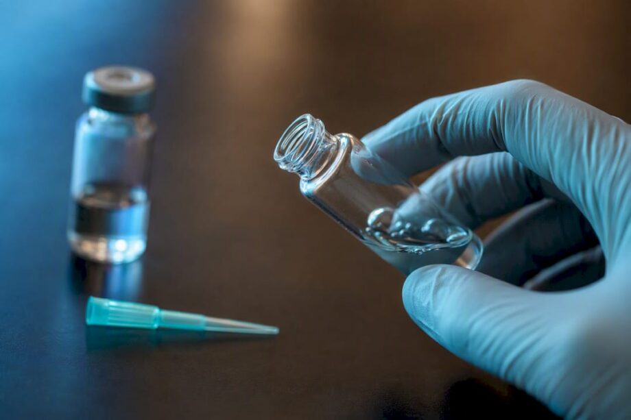 Researcher gently swirling peptide vial
